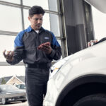 Ford service mechanic performing an oil change