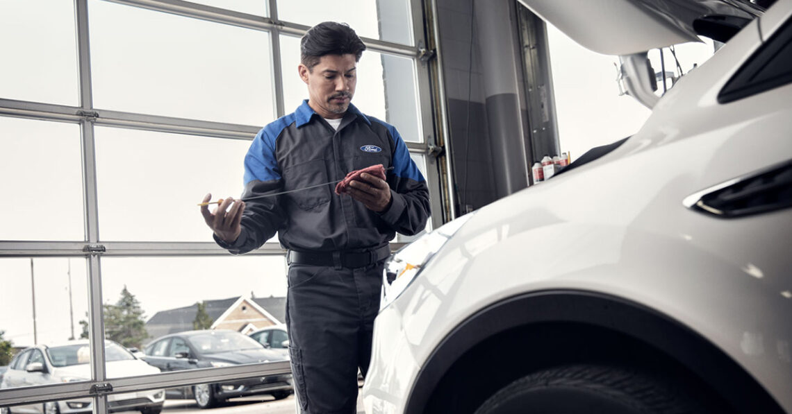 Ford service mechanic performing an oil change